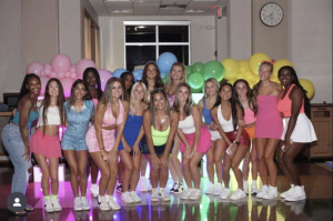 Archmere’s Cheerleading team poses in front of the MORP sign for a group photo. 

